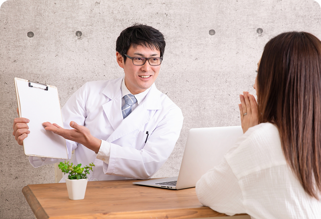 テーブルでお客様に説明する薬剤師